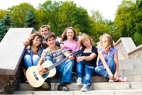 A group of children play guitar together